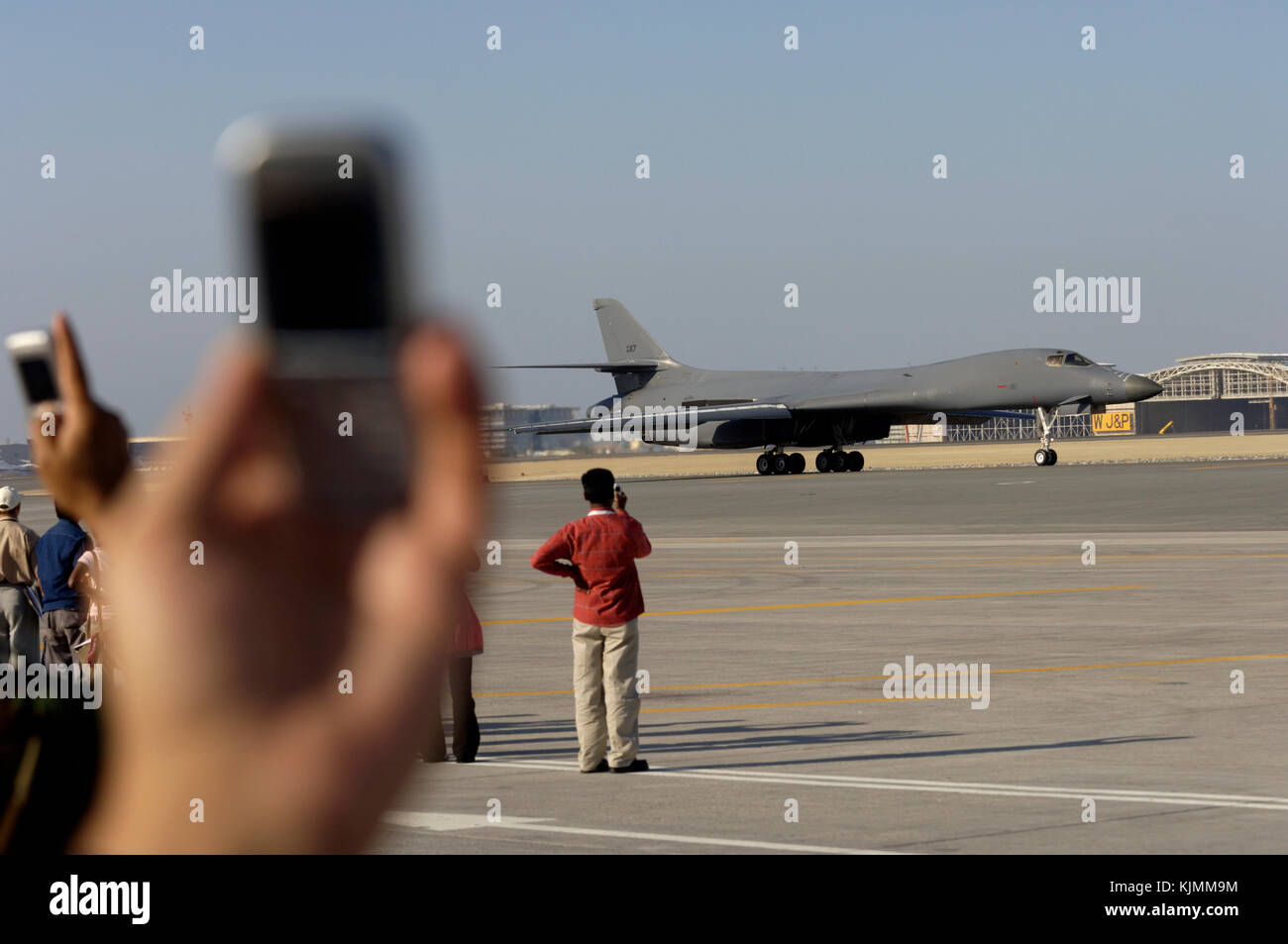 Enthusiasten Beobachten und Fotografieren einer B-1B rollen auf Handy Kameras Stockfoto
