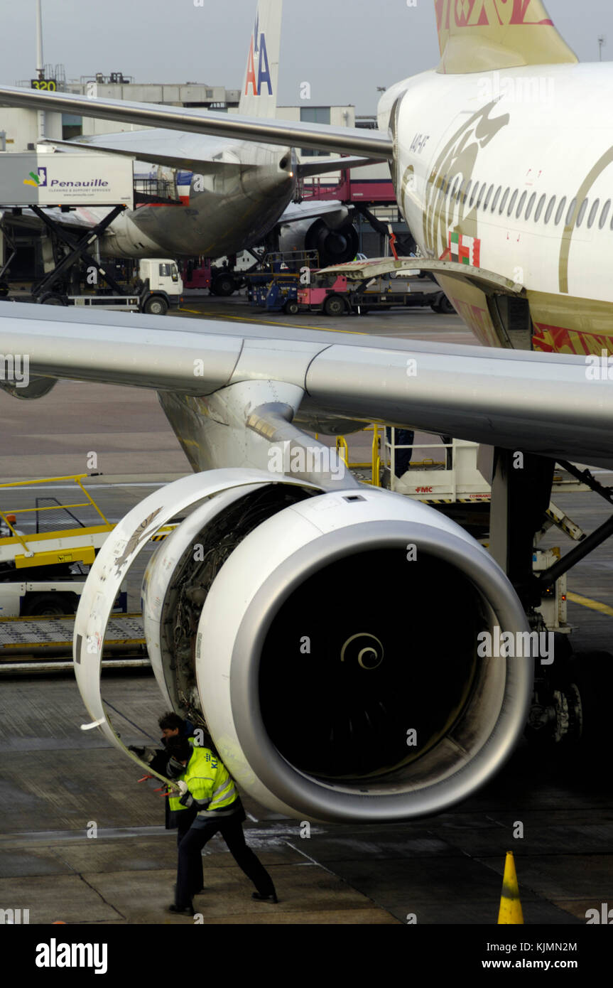 Ein Rolls-Royce Trent 772 B-60 Motor auf einem Gulf Air Airbus A330-200 durch Männer tragen gelbe High viz tabards, während am Terminal 3 wit geparkt ueberprueft Stockfoto