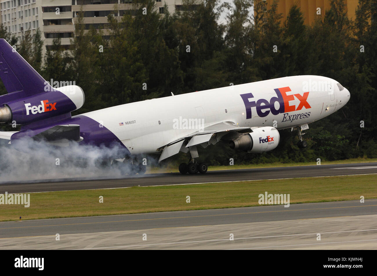 FedEx Federal Express McDonnell Douglas MD-10-10 F Touchdown auf der Landebahn mit Reifen rauchen. Stockfoto