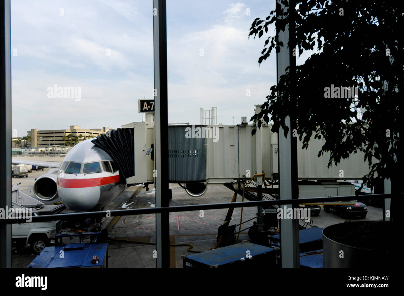 Windschutzscheibe von einem American Airlines Boeing 777-200ER am Tor mit jetway, Schlepper und Lkw geparkt Stockfoto