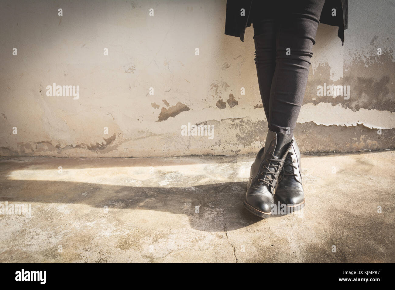 Eine Frau, die Beine tragen schwarze Stiefel mit hohem Absatz. sepia Ton. Stockfoto