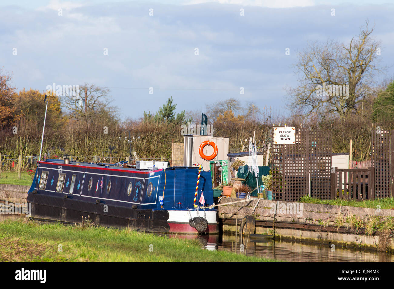 Schmalboot mit Bitte Slow Down Zeichen auf dem Trent und Mersey Kanal in Elworth Sandbach Cheshire UK Stockfoto