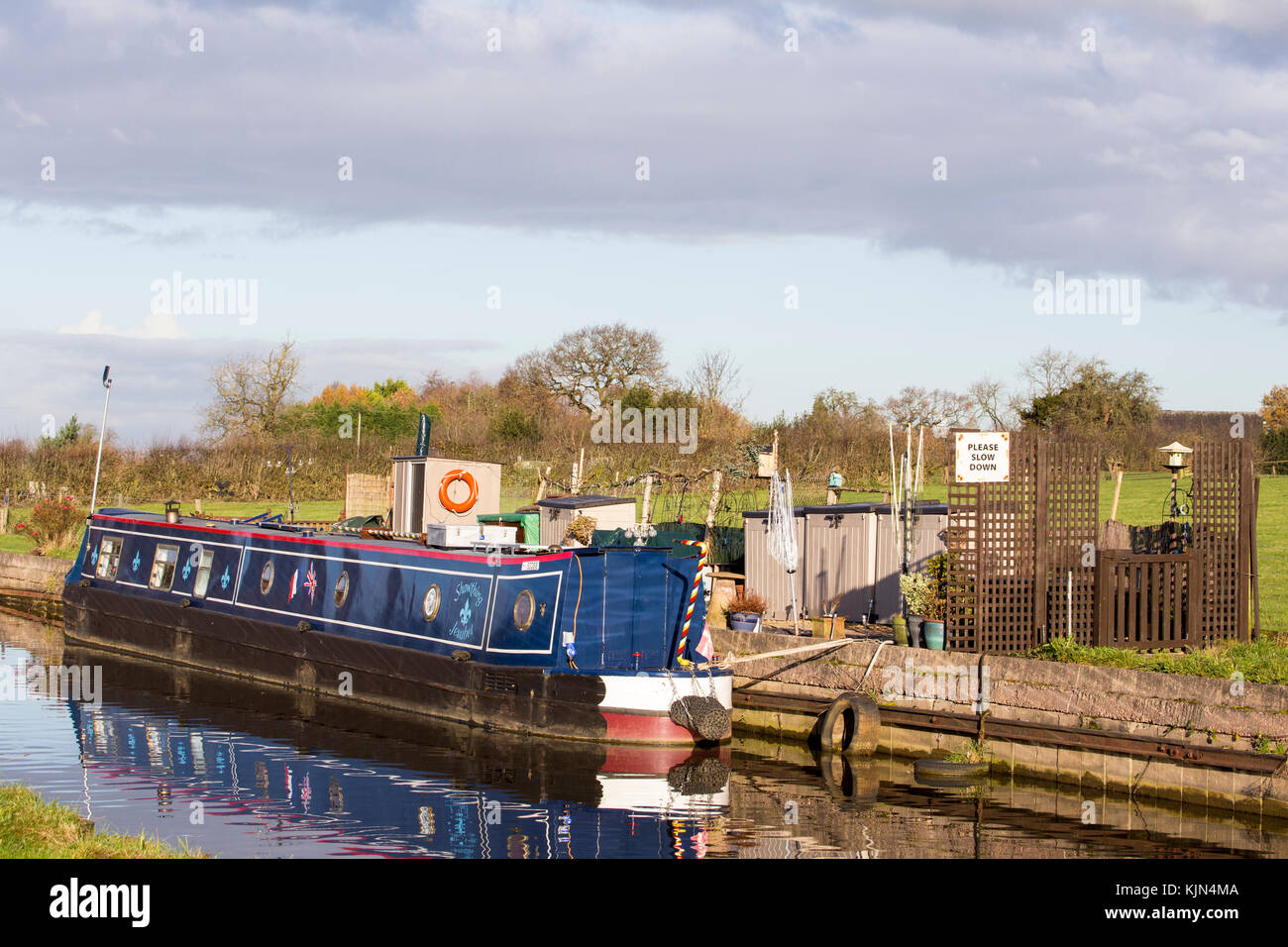 Schmalboot mit Bitte Slow Down Zeichen auf dem Trent und Mersey Kanal in Elworth Sandbach Cheshire UK Stockfoto