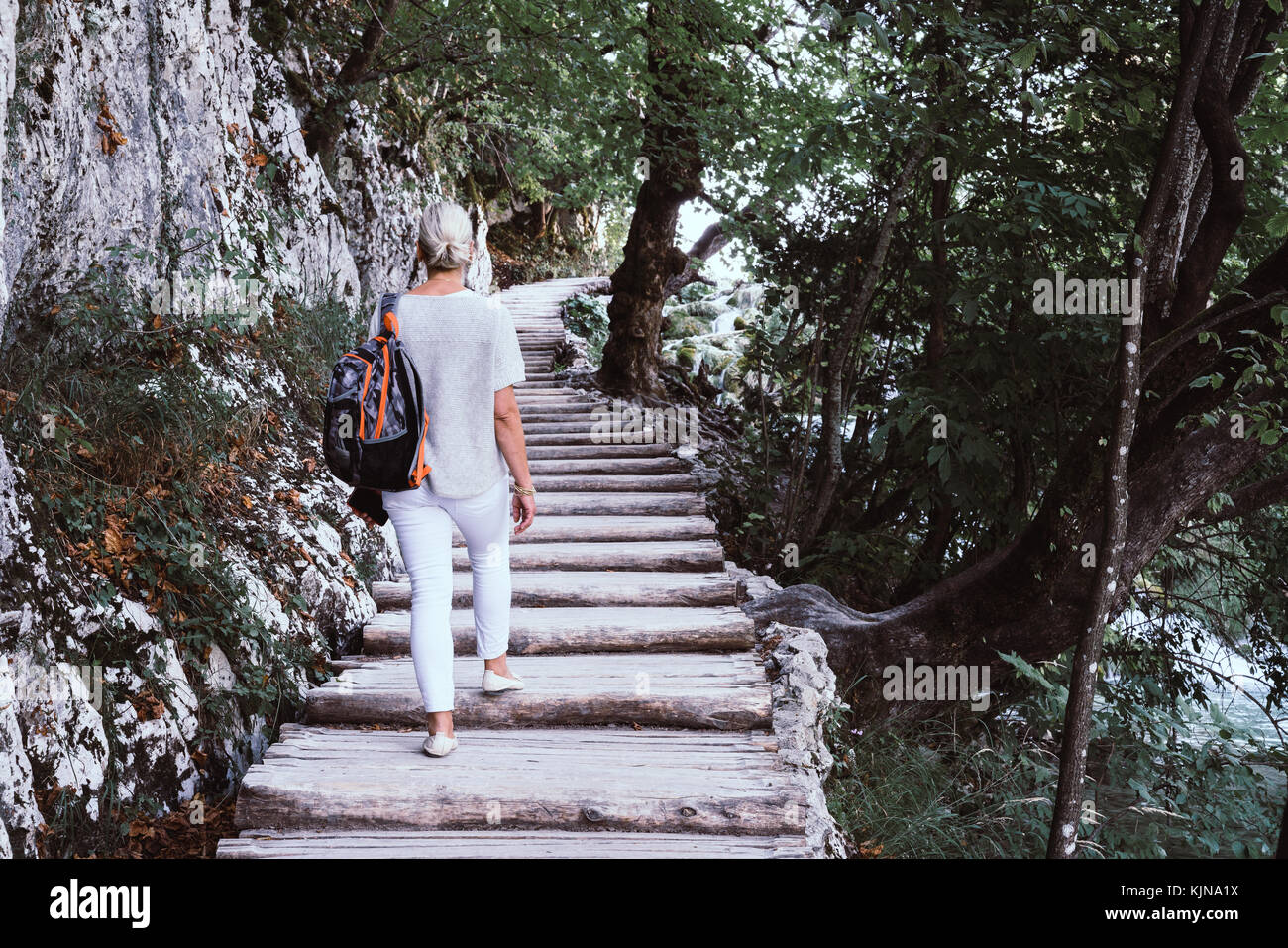 Die Frau ist auf einem Weg entlang eines Baches im Nationalpark Plitvicer Seen in Kroatien Stockfoto