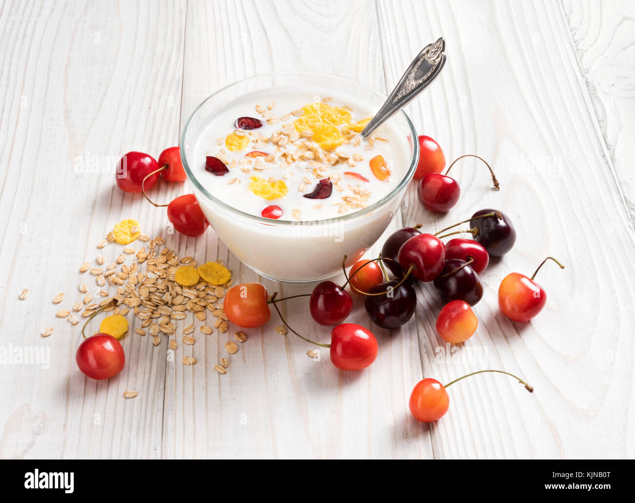 Schüssel mit hausgemachtem Joghurt mit Müsli und frischen Kirsche auf Holztisch. frischen Joghurt. gesunde Ernährung Konzept. hohe Auflösung Produkt. Stockfoto