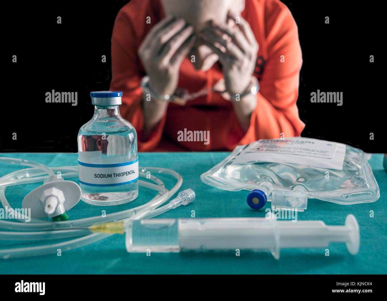 Gefangener in Handschellen zum Tod durch die Giftspritze, Durchstechflasche mit Natrium thiopental und Spritze auf einem Tisch, konzeptionelle Bild Stockfoto