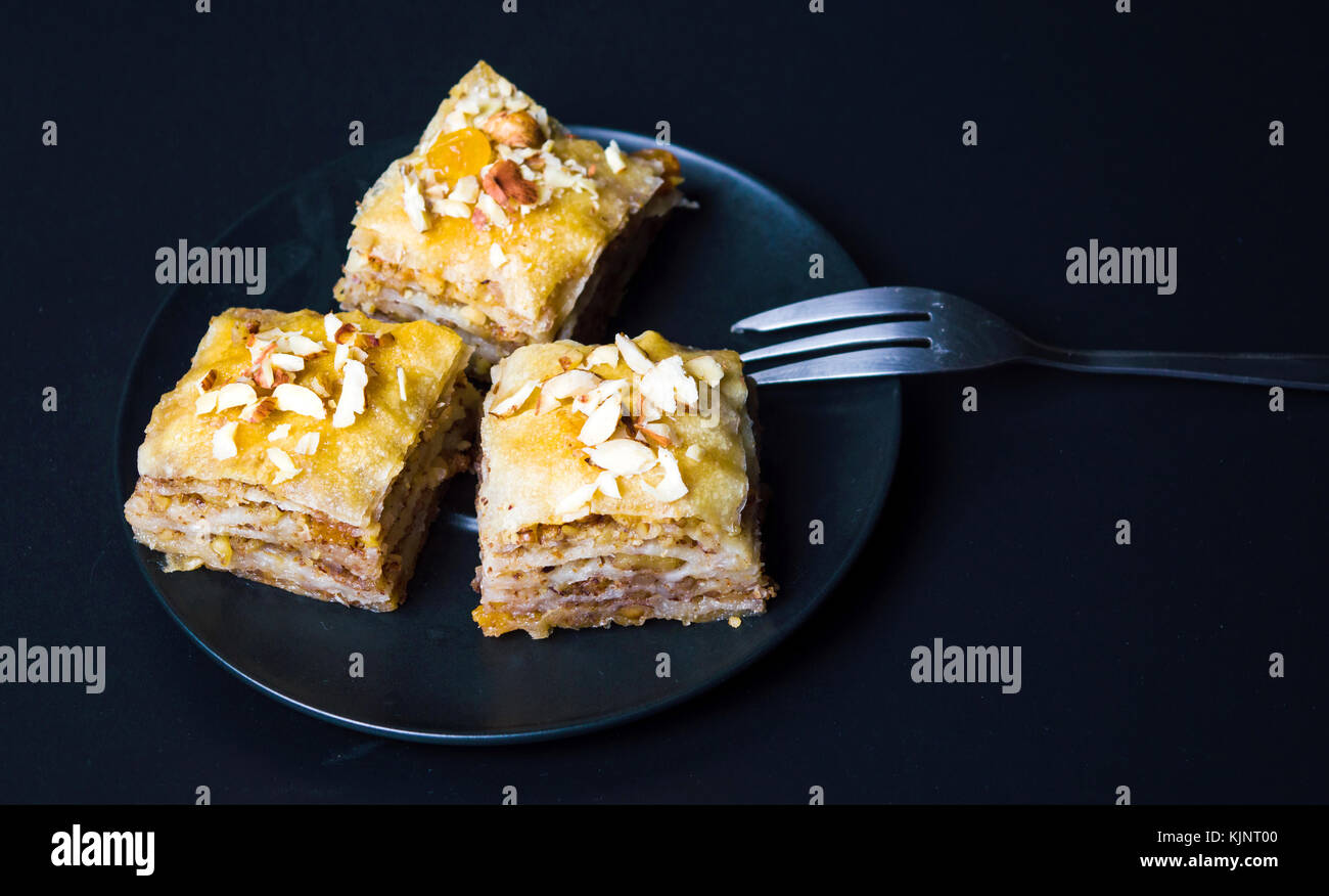 Baklava dessert Schichten mit Muttern auf dunklem Hintergrund Stockfoto