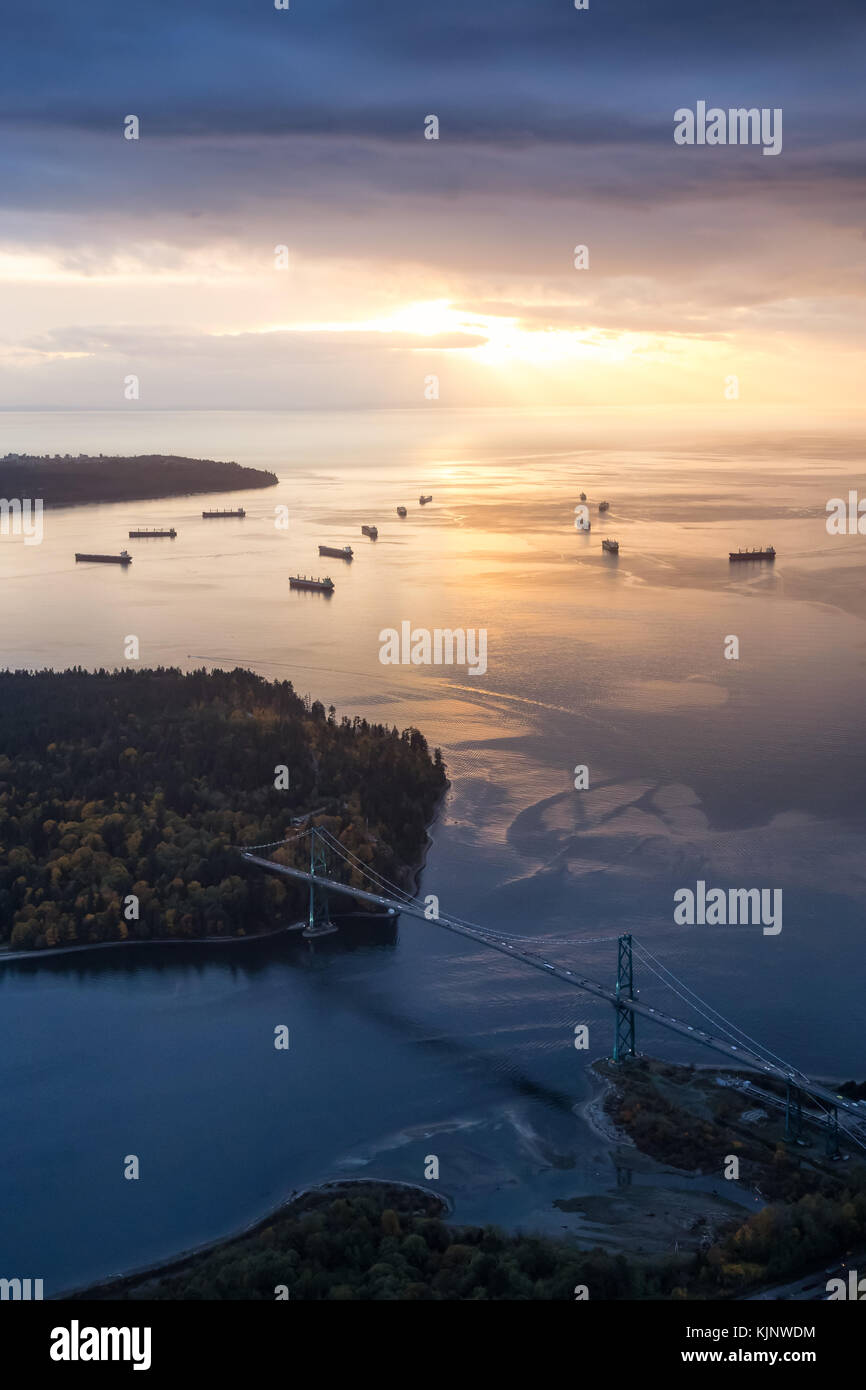 Luftaufnahme von Lions Gate Bridge und Stanley Park während einer stürmischen Wolke bedeckte Himmel vor Sonnenuntergang. in North Vancouver, British Columbia, Kanada. Stockfoto