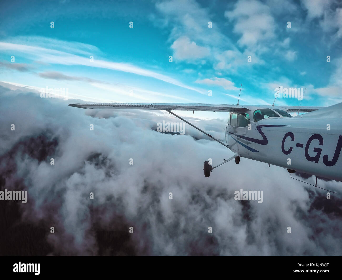 Nördlich von Vancouver, British Columbia, Kanada - 22. Oktober 2017 - Flugzeug im Himmel mit Wolken um Berge während einer lebhaften Eve fallen Fliegen Stockfoto