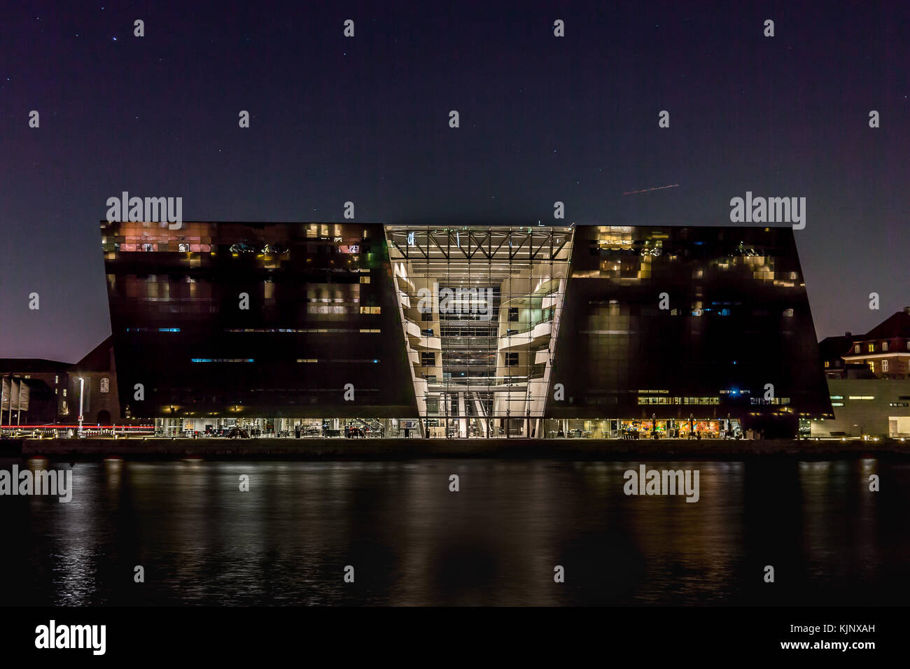 Der schwarze Diamant, der Nationalen Dänischen Bibliothek bei Nacht. Reflexionen im Wasser. Kopenhagen, Dänemark, 23. November 2017 Stockfoto