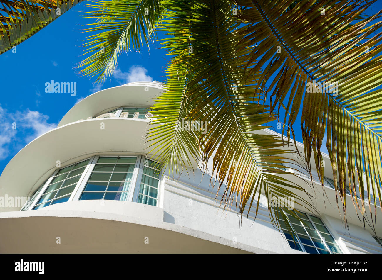 Classic gebogen 1930s Art déco-Architektur und Palmen gegen den blauen Himmel am Ocean Drive in South Beach, Miami, Florida, USA Stockfoto