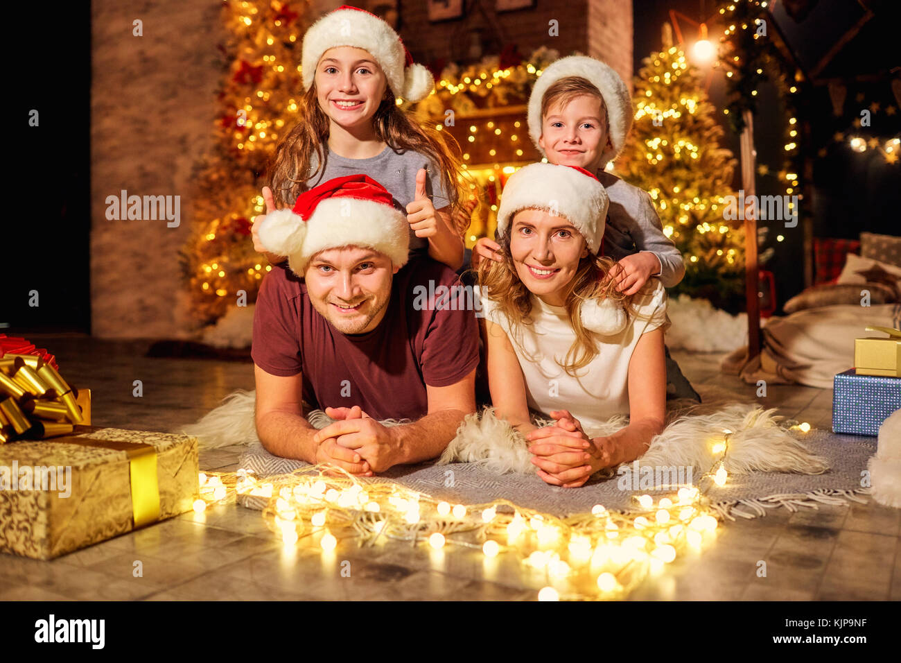 Familie in einem Zimmer mit einem Weihnachtsbaum am Weihnachtstag. Stockfoto