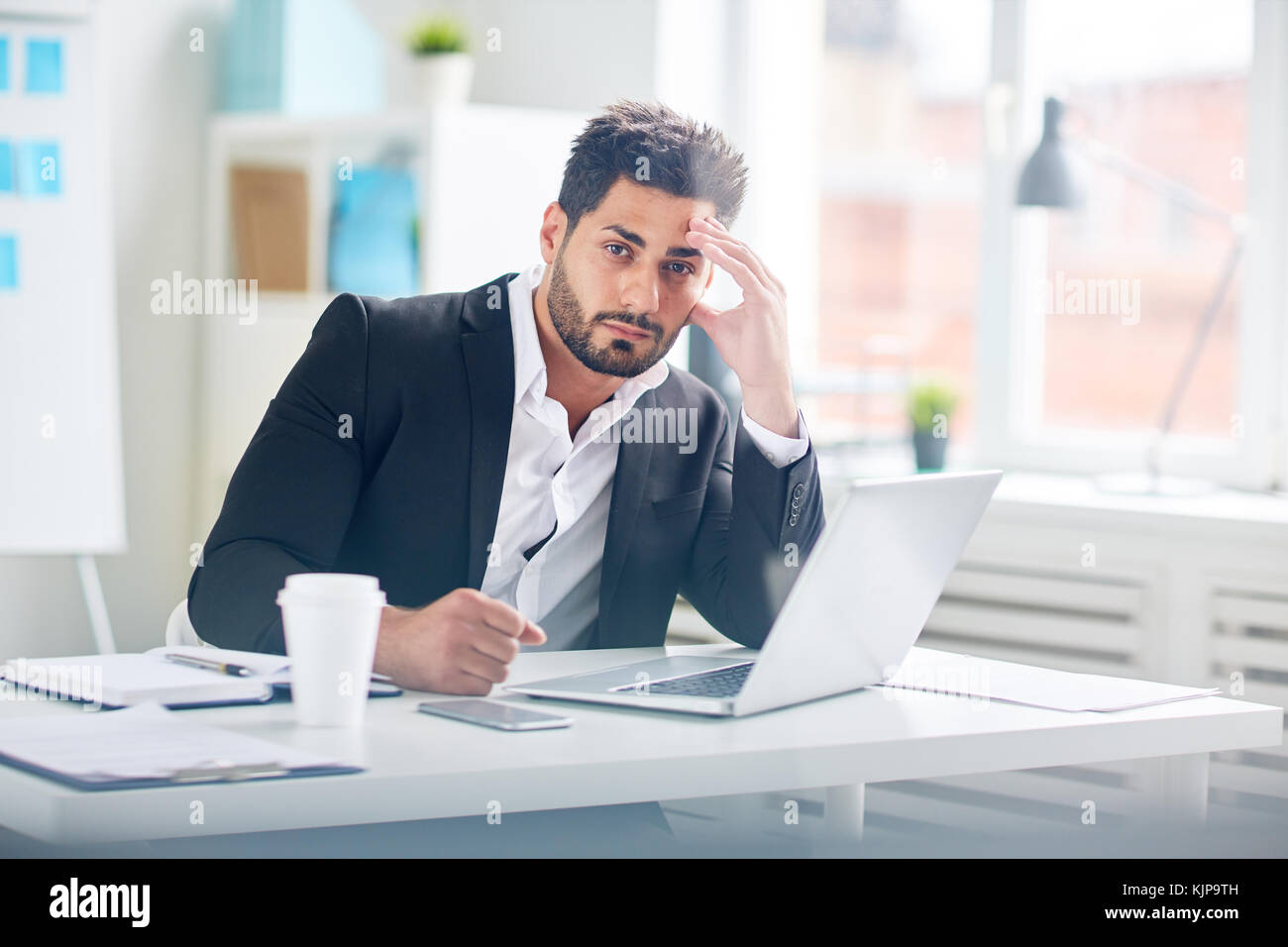 Nachdenklich Geschäftsmann konzentriert sich auf die Arbeit der Organisation oder der Lösung der finanziellen Probleme sitzen vor dem Laptop im Büro Stockfoto