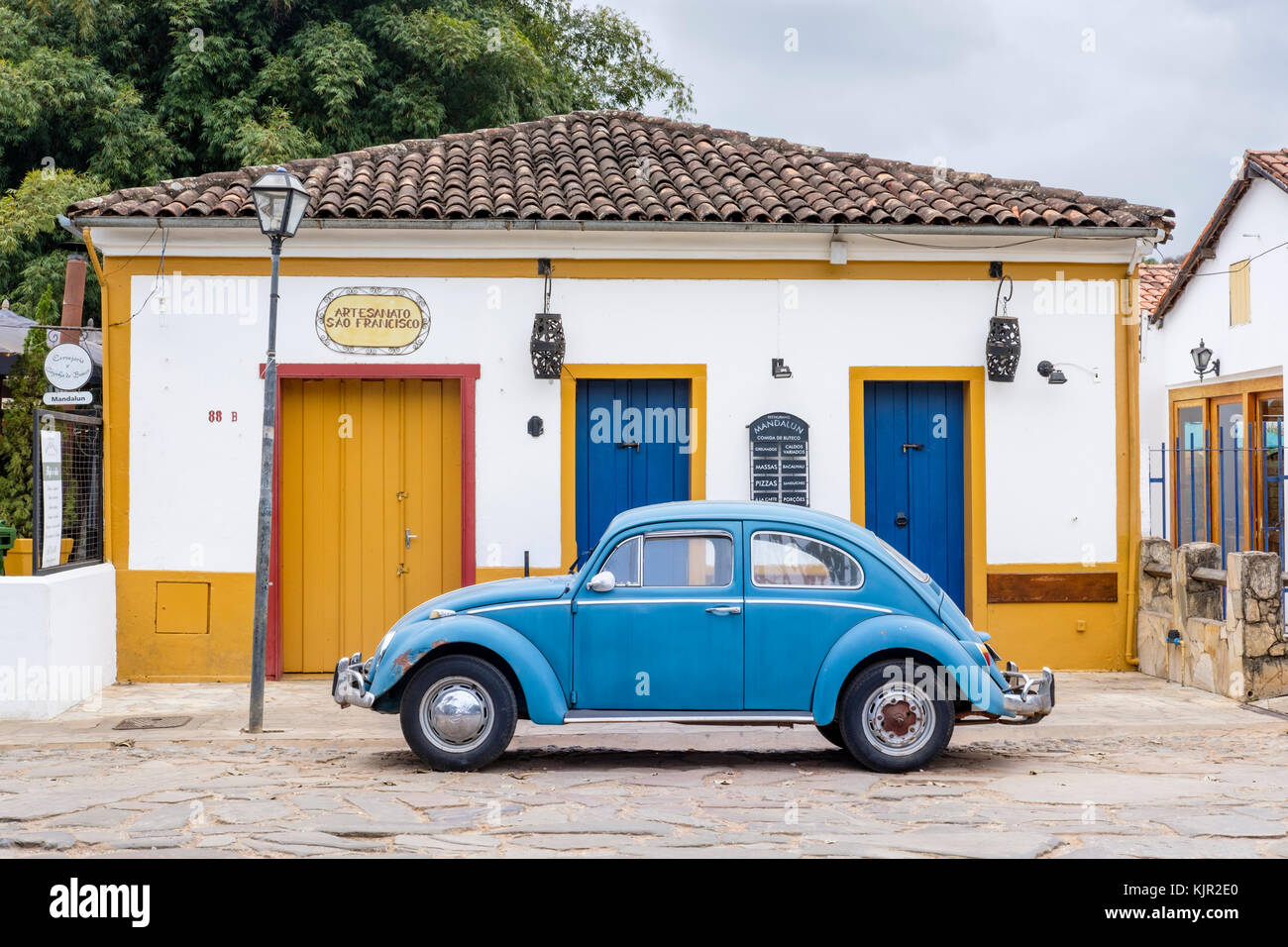 Gelbes Haus im Kolonialstil, Blau Volkswagen Käfer, Straße mit Kopfsteinpflaster, Tiradentes, Minas Gerais, Brasilien. Stockfoto