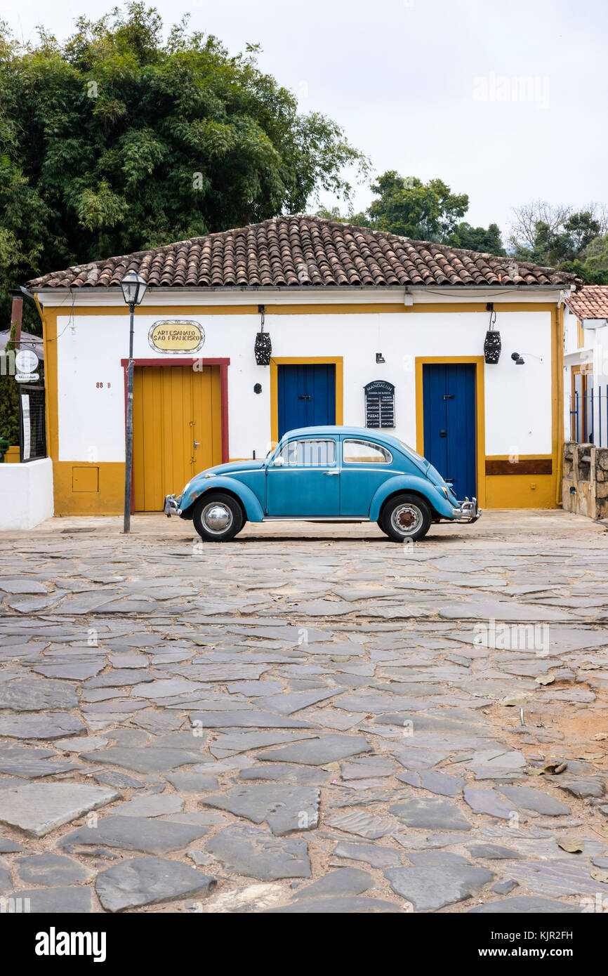 Gelbes Haus im Kolonialstil, Blau Volkswagen Käfer, Straße mit Kopfsteinpflaster, Tiradentes, Minas Gerais, Brasilien. Stockfoto