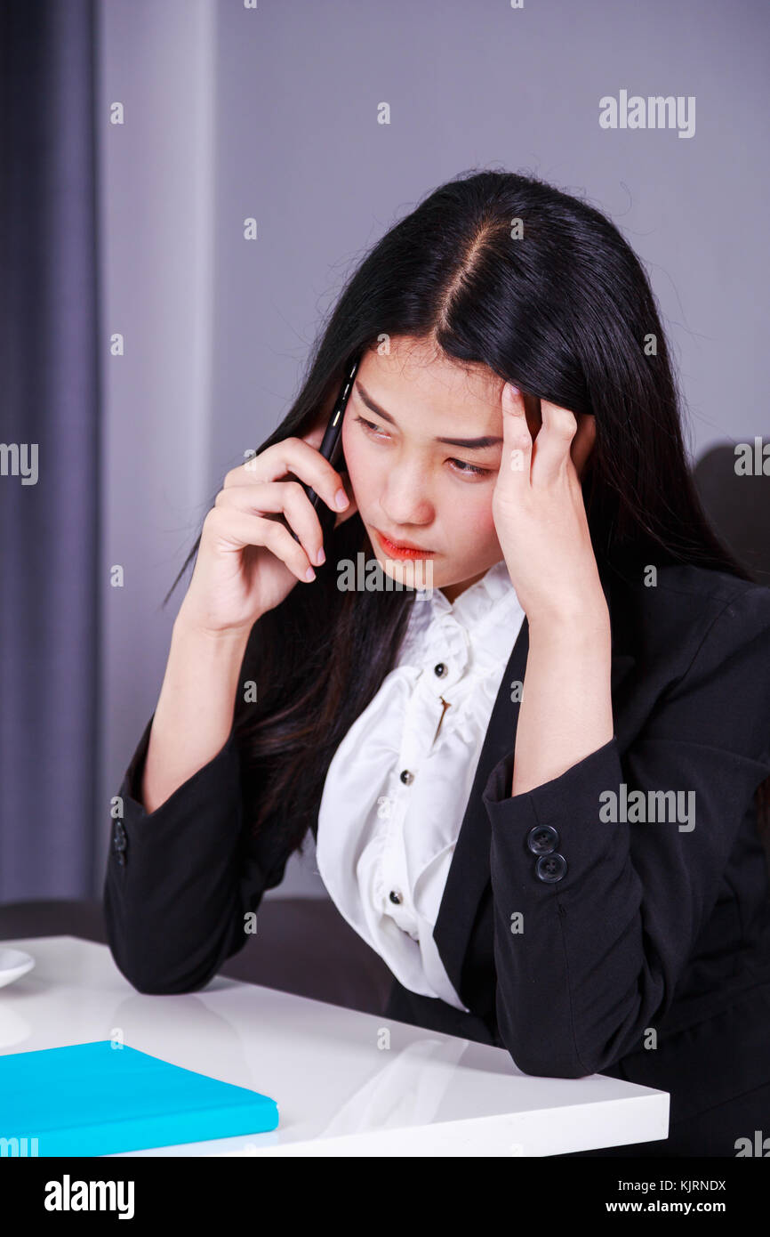 Frau in Business Anzug im Stress verzweifelt auf ein Handy arbeiten Stockfoto