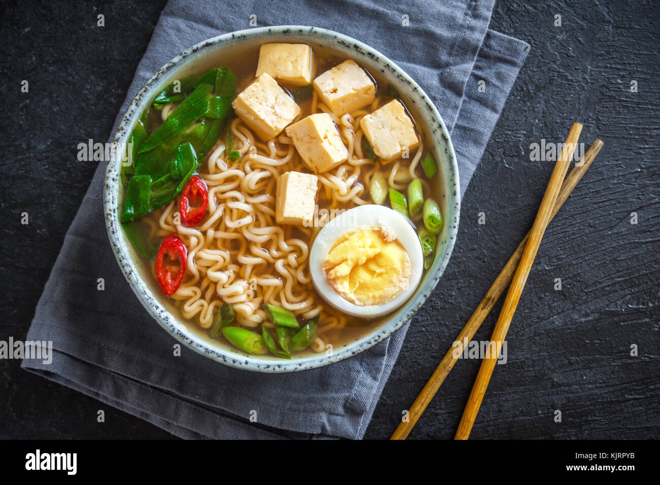 Japanische Ramen-Suppe mit Tofu und Ei auf dunklem Stein. Miso-Suppe ...