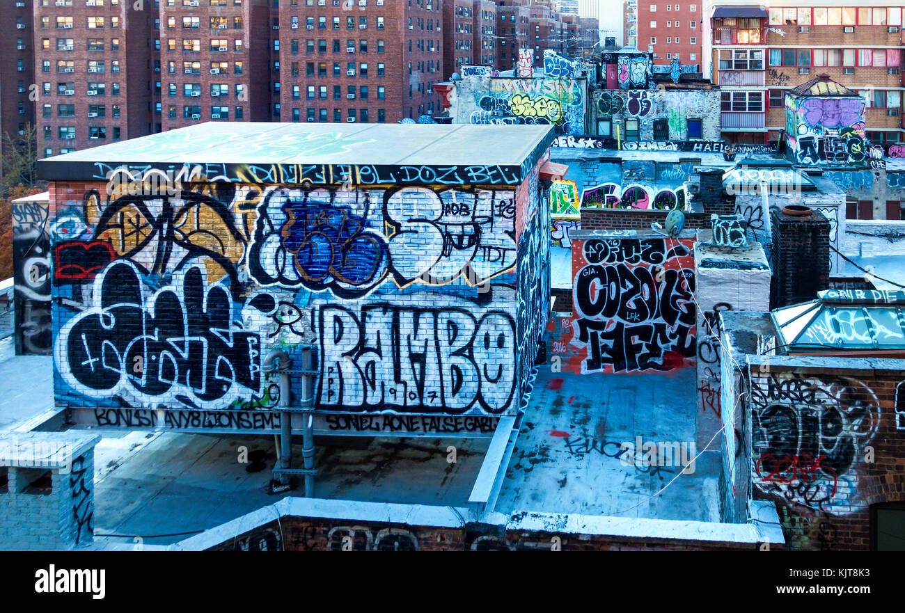 Graffiti oder Street Art über den Dächern von mietskasernen Gebäude in New York City's Lower East Side Stockfoto