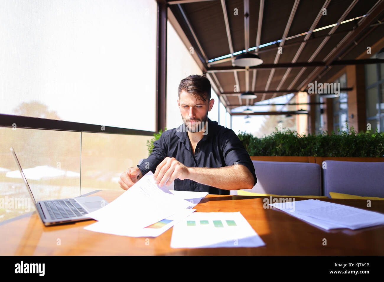 Büroangestellter sortieren Papiere auf dem Tisch in der Nähe der Räder. Stockfoto