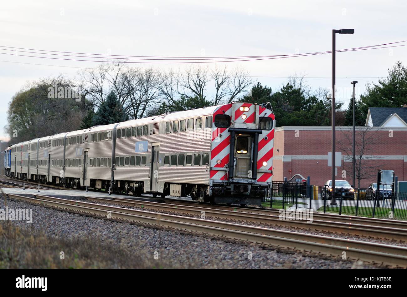 Eine eingehende Metra Zug transportiert Pendler zu Chicago in die Vorstadt Lombard, Illinois Bahnhof. Lombard, Illinois, USA. Stockfoto