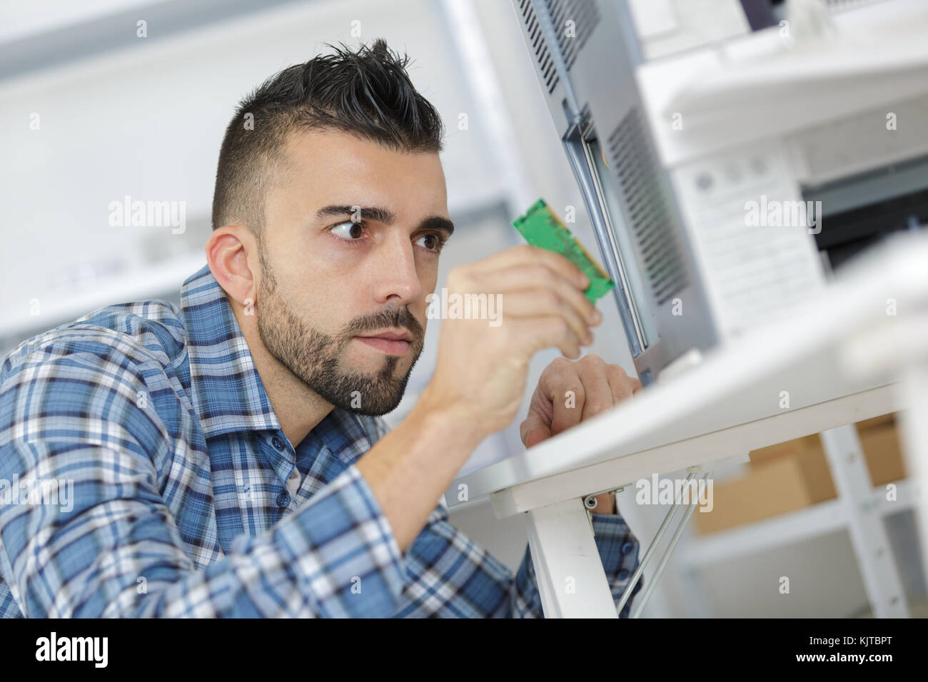 Junge Techniker zur Festsetzung ein Mainboard von screwdrive Stockfoto