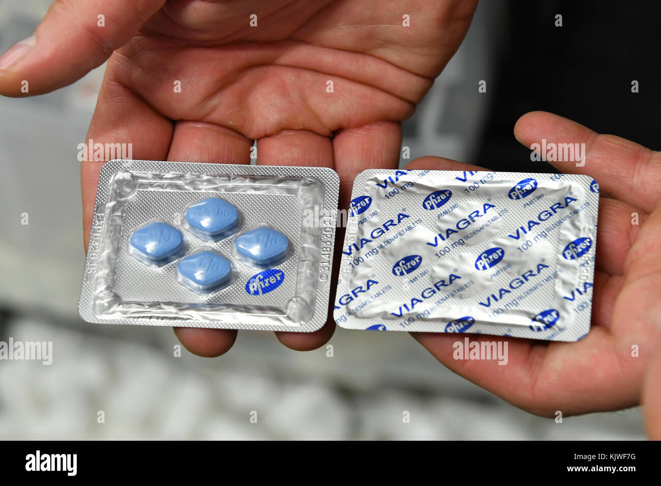 Berlin, Deutschland. November 2017. Ein Zollbeamter hält viagra-Tabletten in der Hand während einer Pressekonferenz der Zollbehörden in Berlin am 27. November 2017. Sie gehören zu einem beschlagnahmten, fast zwei Tonnen umfassenden Fund von Dopingsubstanzen und Medikamenten aus einem unterirdischen Labor. Die Ermittler fanden die Produkte bereits im Mai. Fünf Männer wurden am 21. November 2017 vom Landgericht Augsburg zu Haft verurteilt. Quelle: Paul Zinken/dpa/Alamy Live News Stockfoto