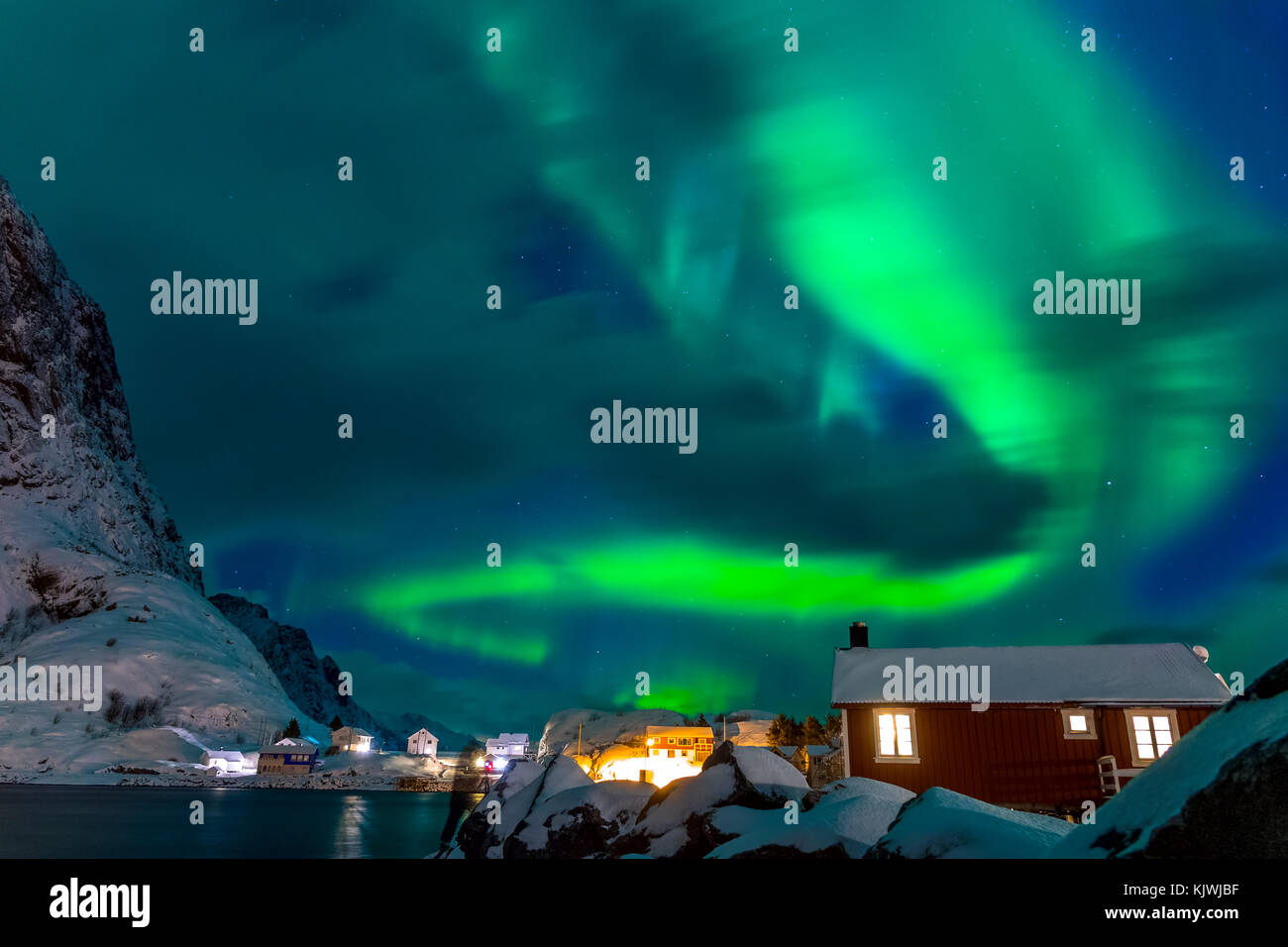 Winter in Norwegen. Lofoten. Hamnoya Stadt. Aurora Borealis über den Dächern der Häuser Stockfoto