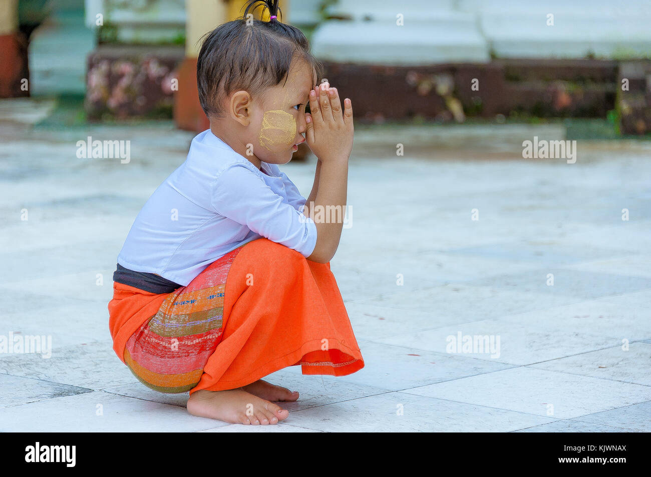 Shwedagon Pagode, Yangon, Myanmar - Oct 21, 2017: Ein wenig burmesischen Junge kniet sich wie er umklammert seinen Handflächen und betet zum Herrn Buddha. Stockfoto