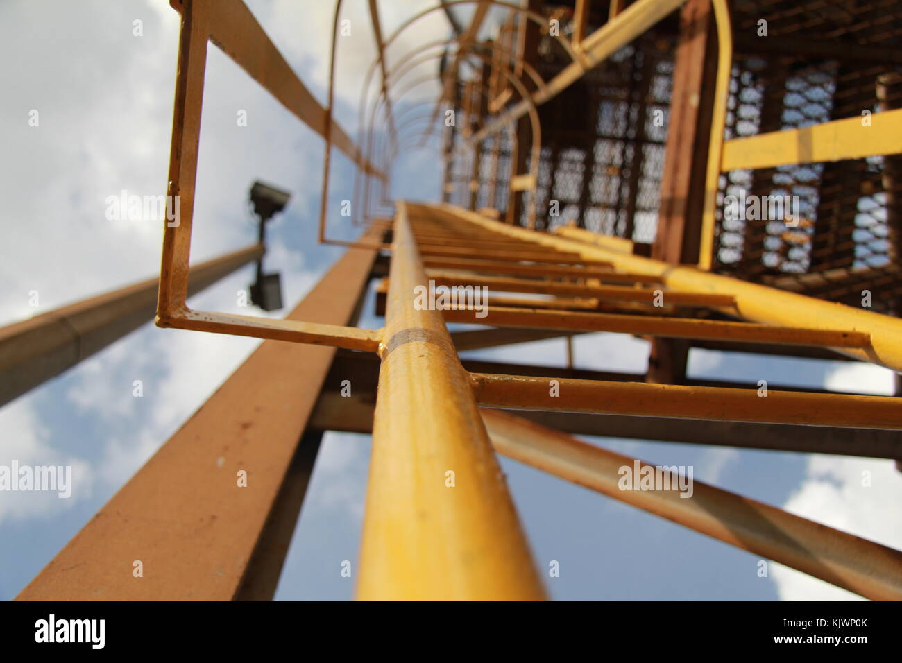 Industrielle gelbe Leiter unter dem Himmel Stockfoto