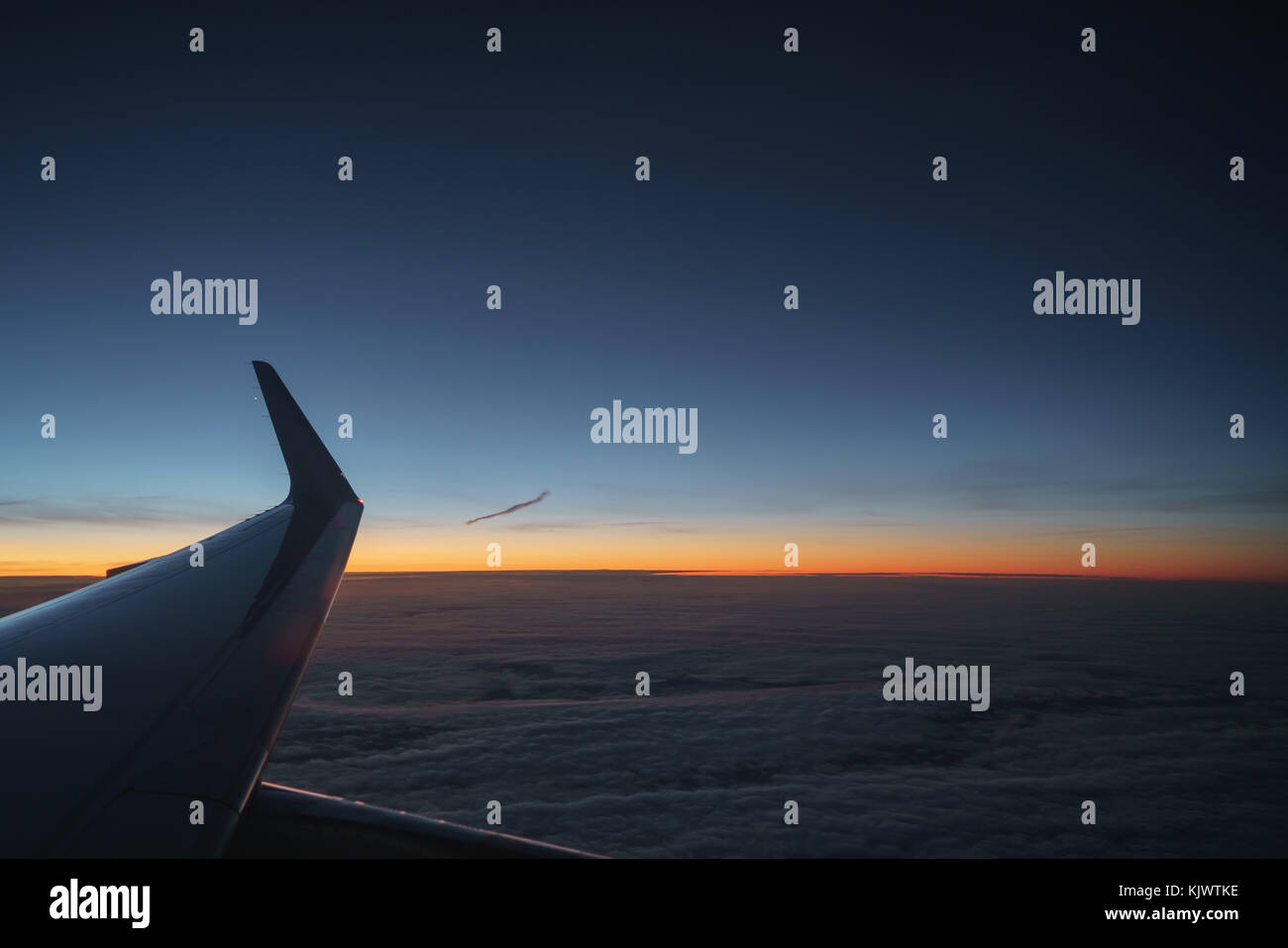 Luftaufnahme von Flugzeug Flügel im Sonnenaufgang während des Fluges Stockfoto