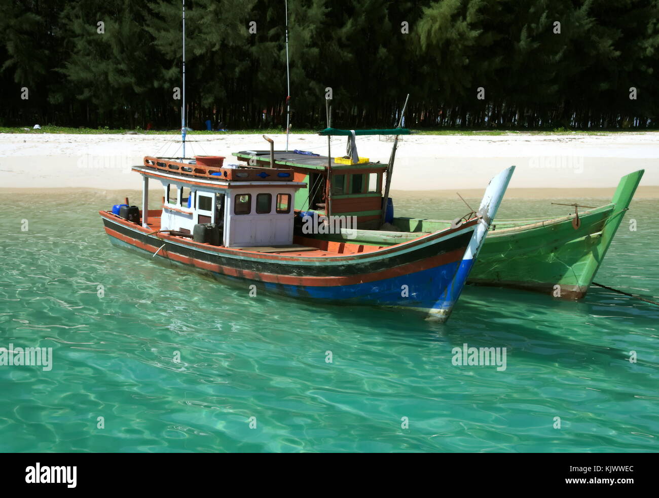 Fischerboote in der Nähe von einem Strand, schwimmend auf durchsichtigem Wasser, in Thailand. Stockfoto