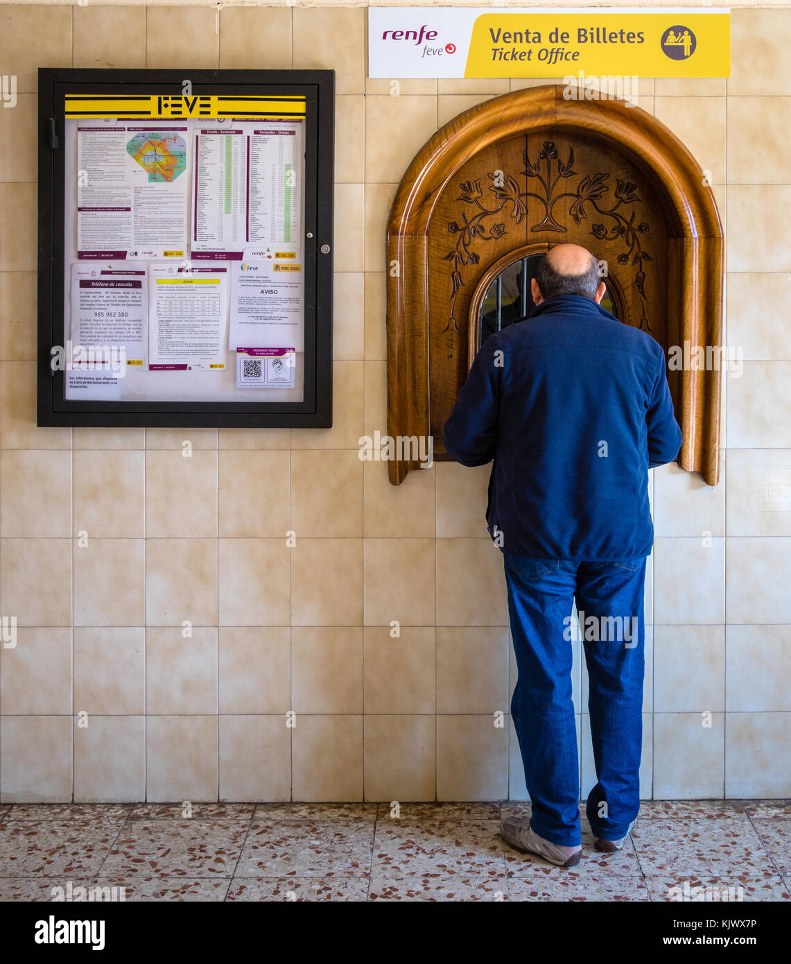 Ein Mann am Ticket Office Fenster auf der Renfe Feve Schmalspurbahn in Gijon Bahnhof im Norden Spaniens Stockfoto