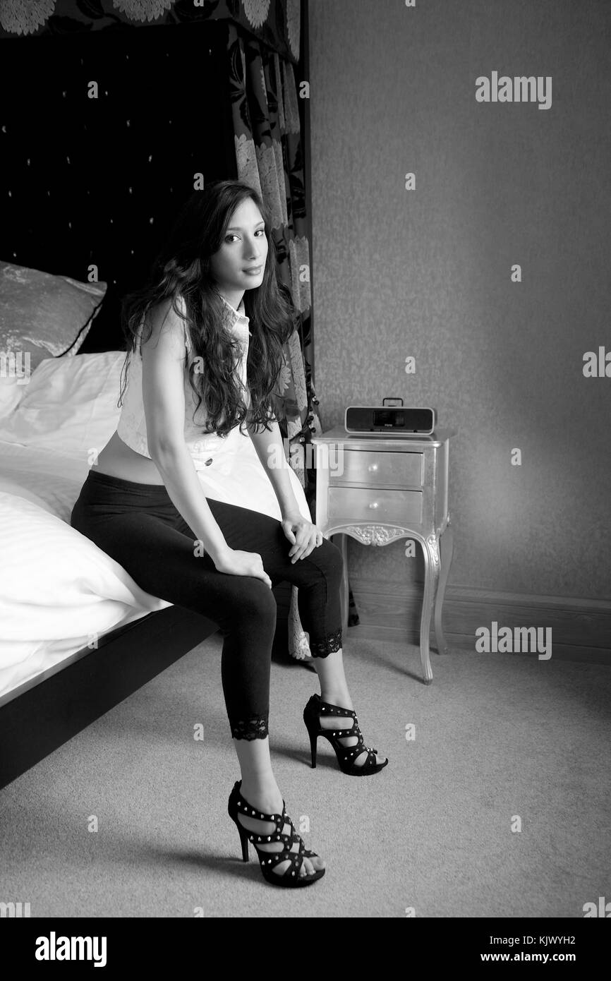 Schöne brünette Mädchen mit schwarzen Leggings in einem Schlafzimmer Lage Stockfoto