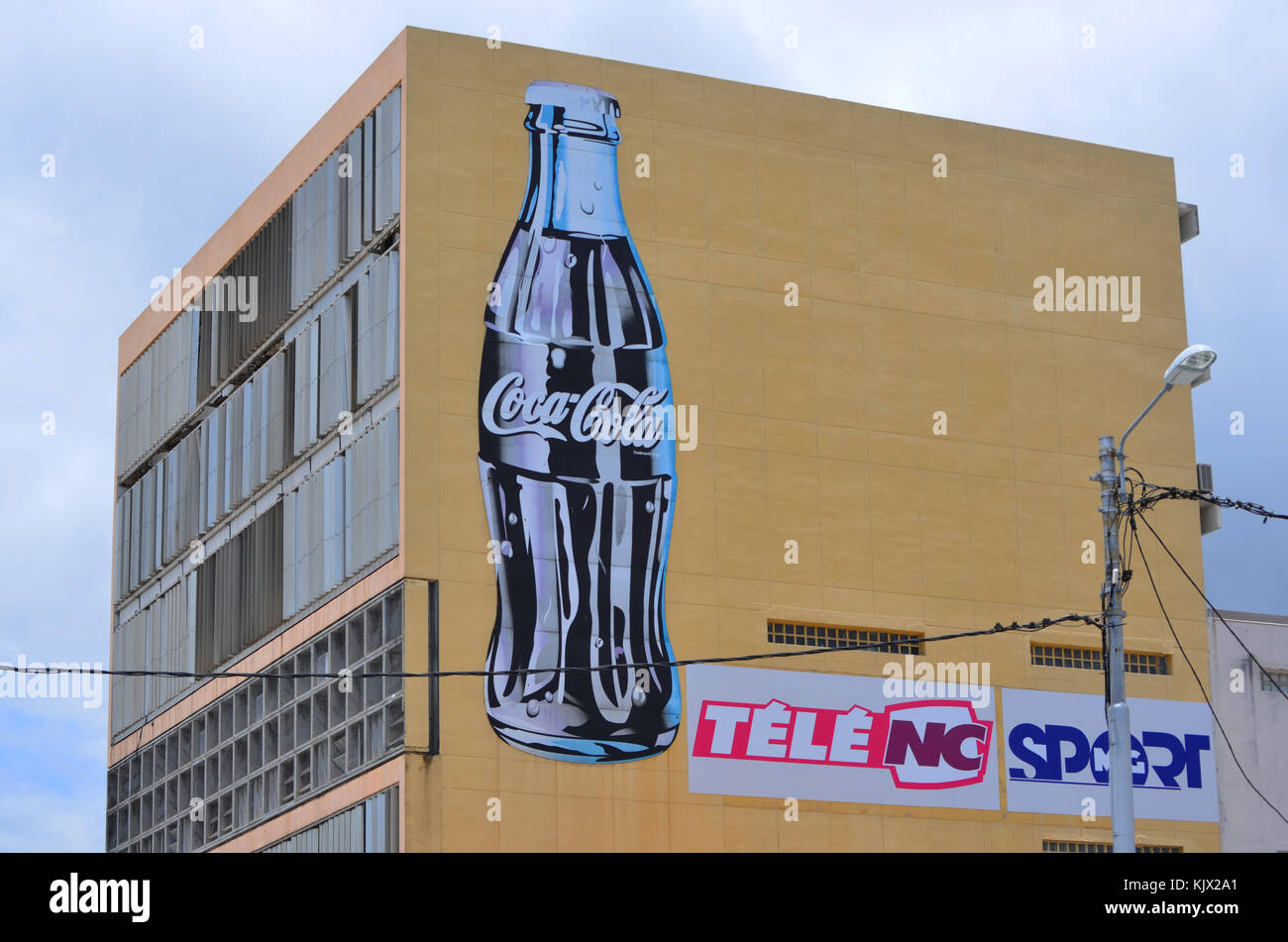 Coca-Cola-Flaschenschild an der Seite des Gebäudes in Noumea Stockfoto