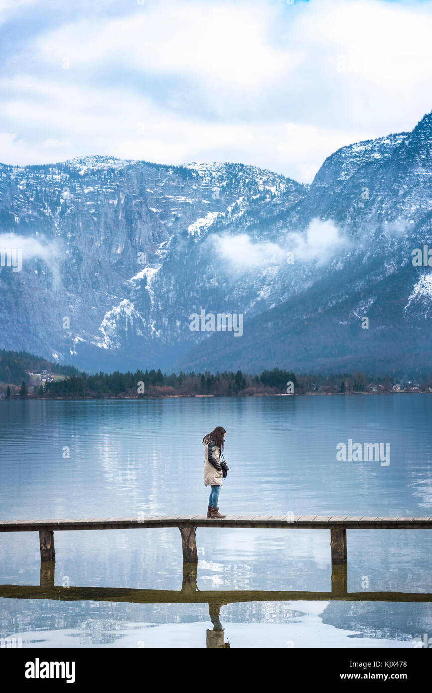 Tourismus Bild von einer Frau mit einem Foto Kamera, wandern auf einem Holzdeck über dem Hallstätter See, durch die nördlichen Kalkalpen umgeben, Österreich Stockfoto