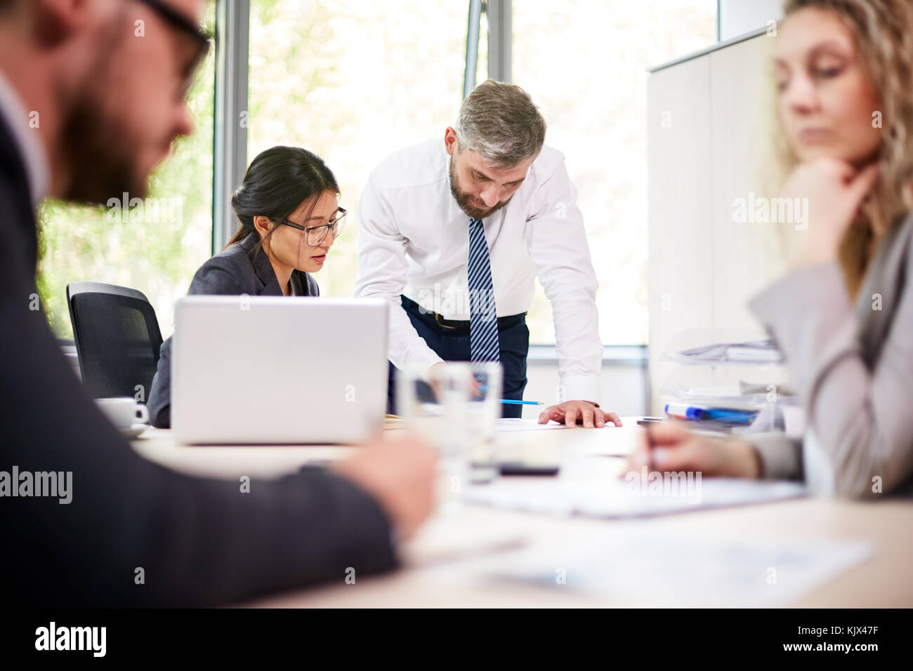 Arbeitstreffen mit voller Geschwindigkeit: multi-ethnischen Gruppe von Managern zusammen an Sitzungssaal versammelt und Diskussion gemeinsames Projekt Stockfoto
