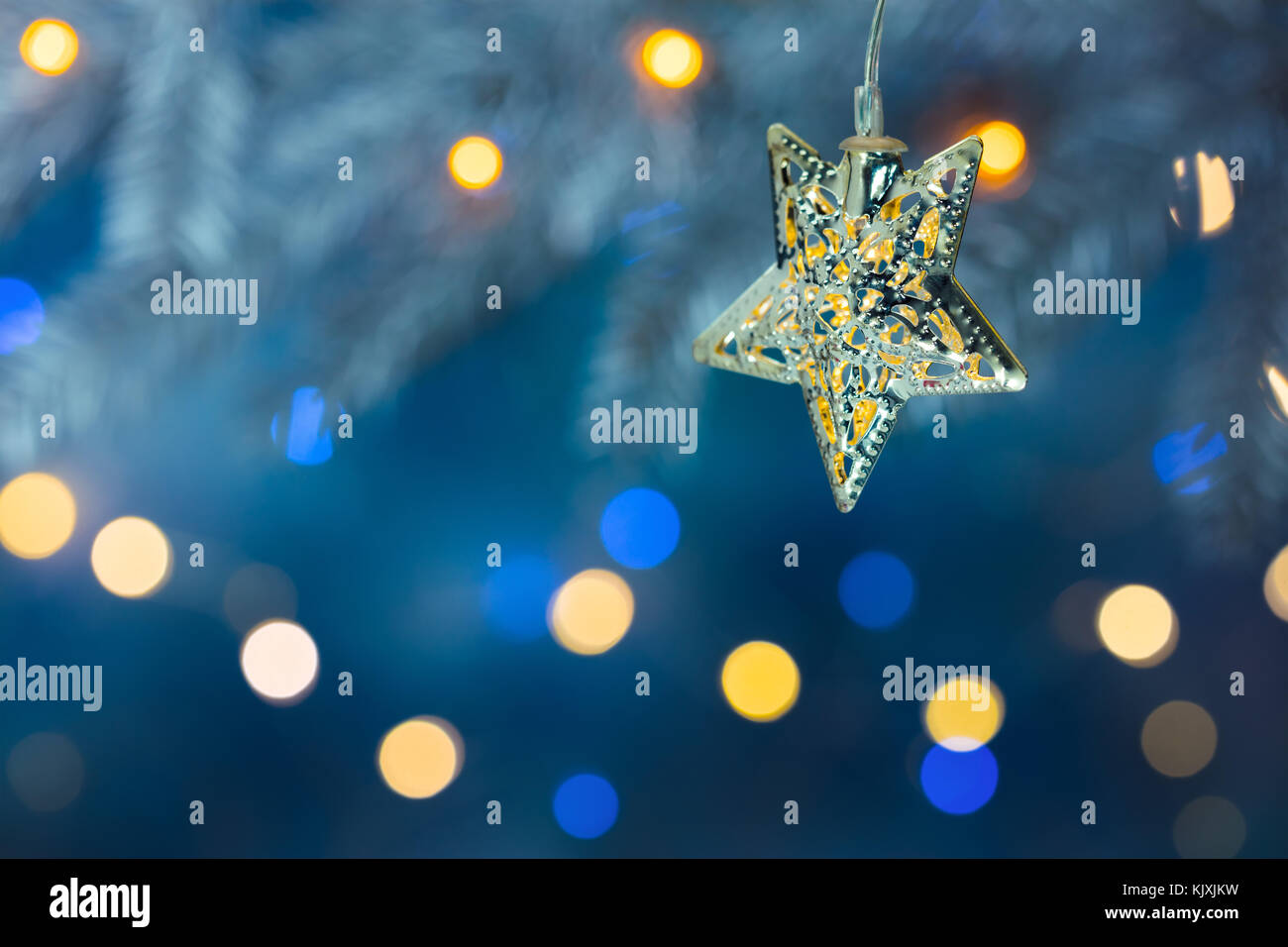 Christmas tree branch mit Girlanden geschmückt. defokussierten Hintergrund blau mit Beleuchtung. Stockfoto