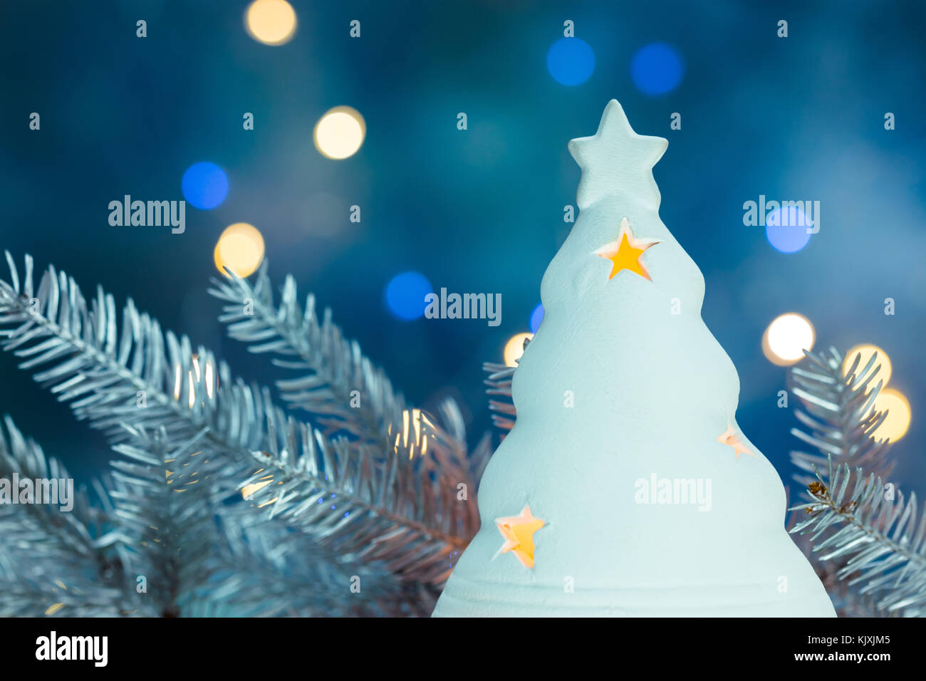 Weiß und Silber Tanne Weihnachtsbaum Zweig auf Hintergrund mit unscharfen Holiday Lights Stockfoto
