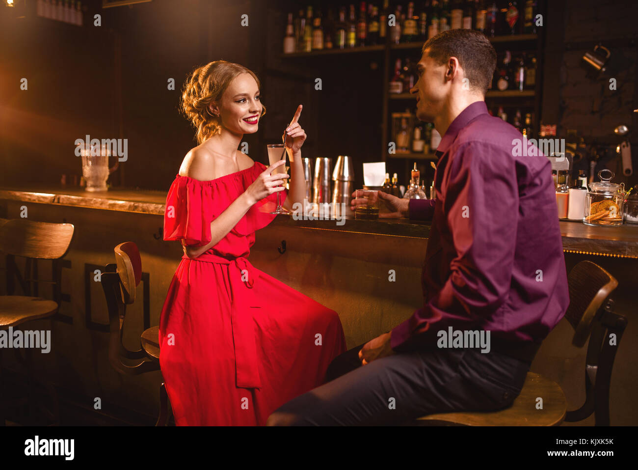 Datum im Nachtclub, attraktive Frau im roten Kleid flirtet mit Mann gegen  bar-Zähler im Nachtclub. Liebe Beziehung, Nacht lifestyle Stockfotografie -  Alamy