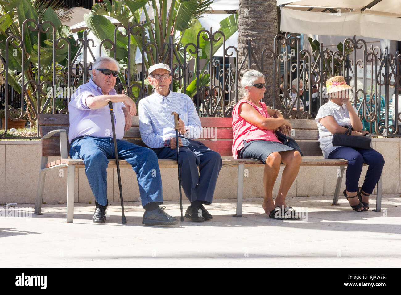 Ältere Menschen saßen auf einer öffentlichen Bank, Sitges, Katalonien, Spanien Stockfoto