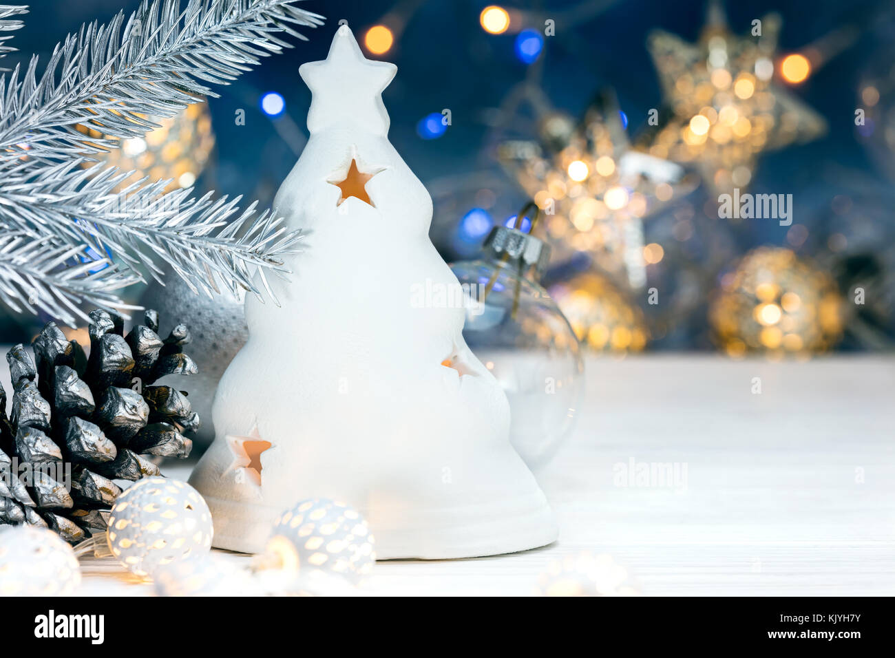 Weihnachtsschmuck, Fir Tree Branch mit Kegel auf unscharfen Hintergrund blau mit Girlande Lichter Stockfoto