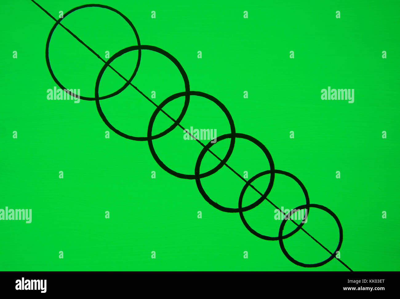 Verkettete schwarze Kreise auf schwarze Linie mit grünem Hintergrund Stockfoto