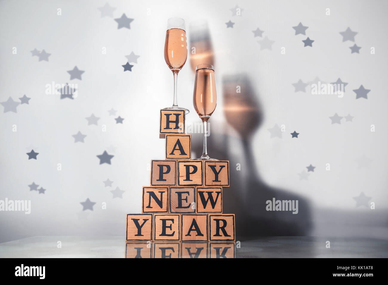 Gläser mit rosigen Champagner eine farbige Schatten und Holzwürfel machen Form der text Frohes neues Jahr Stockfoto