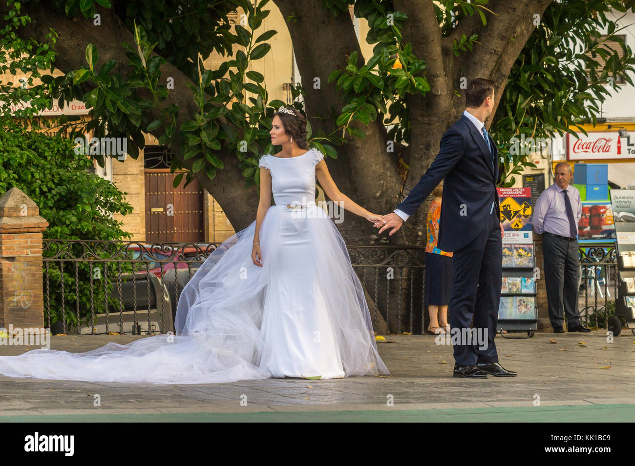 Eine Braut und Bräutigam für Hochzeitsfotos auf dem Triana Brücke, Sevilla, Andalusien, Spanien. Stockfoto