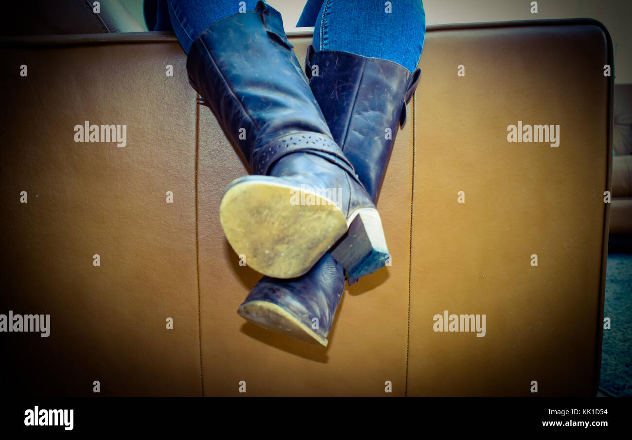 Sich auf dem Sofa abgestürzt, langen Tag erschöpft, genau wie die alten Stiefel Stockfoto