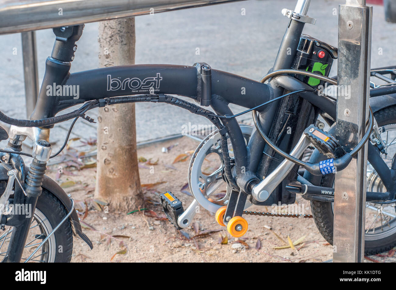 Elektrische brost Fahrrad mit Vorhängeschloss am Pole gebunden Stockfoto