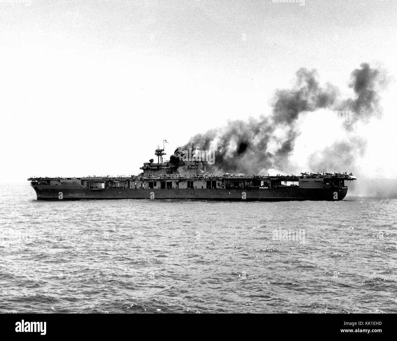USS Yorktown (CV-5) tot im Wasser nach der japanischen Bomben am 4. Juni 1942 getroffen. Das Schiff wurde kurz nach Mittag getroffen. Diese Ansicht wurde etwa eine Stunde später, mit Feuer brennt noch in Ihrem uptakes aber andere sofortige Reparaturen weit fortgeschritten. F4F-4 Kämpfer, die am vorderen Ende der Flight Deck während des Angriffs geparkt worden sind respotted aft, in der AUS-Stellung nehmen. Zwei SBD-3 scout Bomber kann durch die offenen Seiten Ihres nach Hangar Bucht gesehen werden. Stockfoto