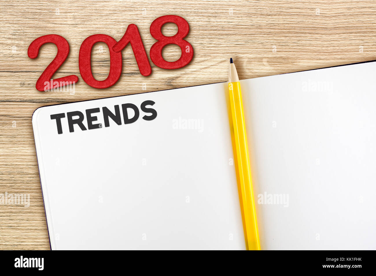 Ansicht von oben 2018 Trends mit leeren öffnen Notebook und gelben Bleistift auf hölzernen Tischplatte, Mock up für das Hinzufügen von ihrem Inhalt oder Design. Stockfoto
