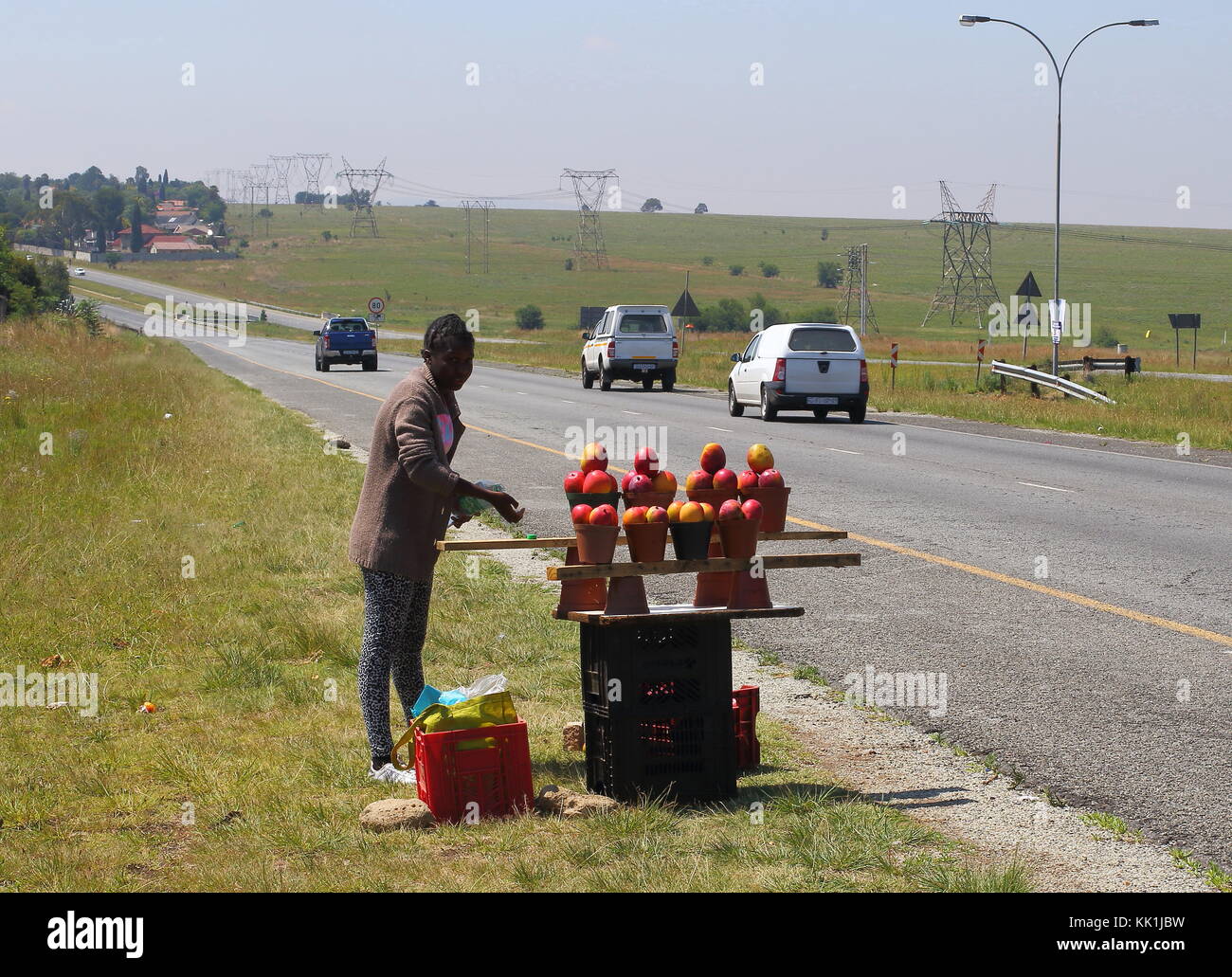 Johannesburg, Südafrika - ein nicht identifizierter Jugend verkauft Mangos zu Führen der Kraftfahrer in einem Versuch, einige Einkommen wie Arbeitslosigkeit zu generieren ist voll Stockfoto