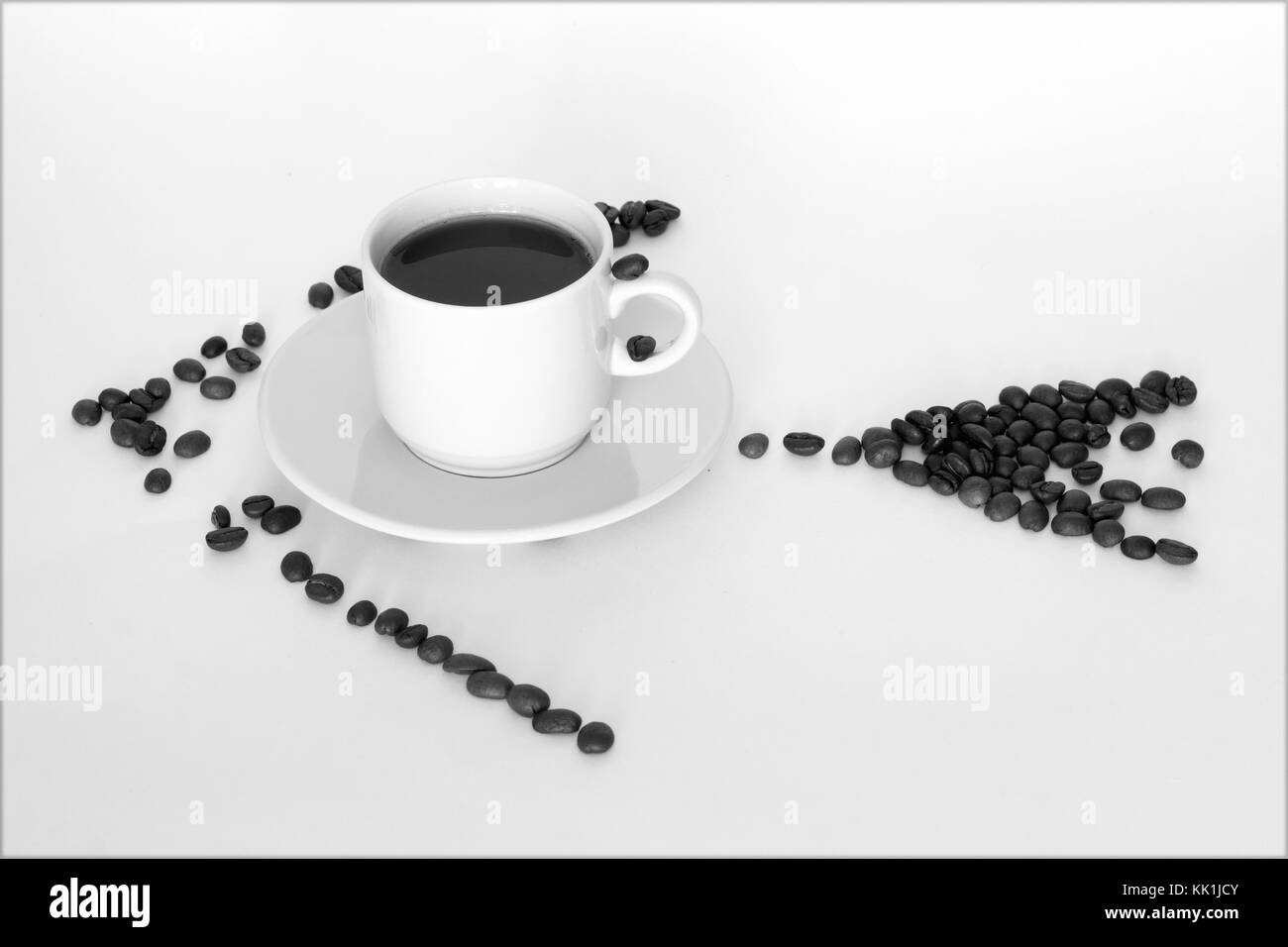 Tasse Kaffee und Kaffeebohnen in Form von Pfeilen auf weißem Hintergrund Stockfoto